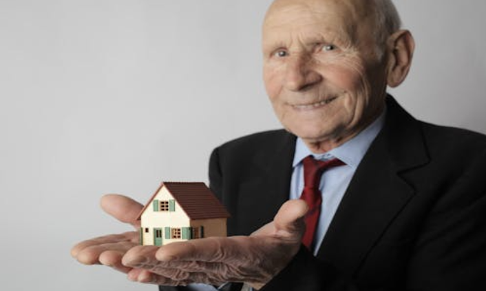 Senior holding a house in their hands